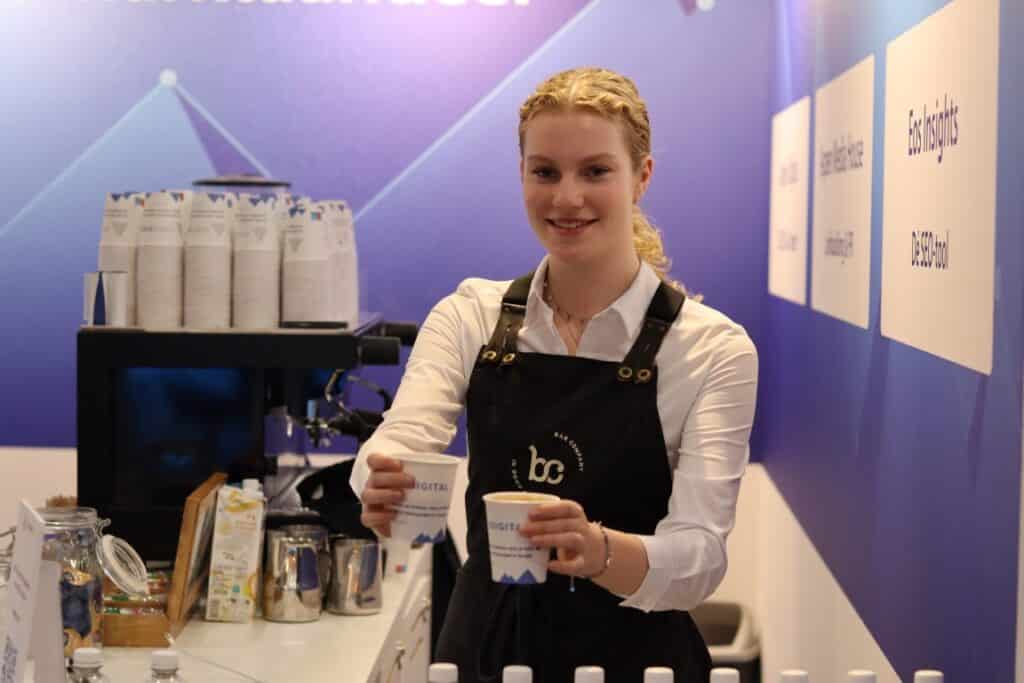 Barista met koffiemachine en koffie op de beursstand